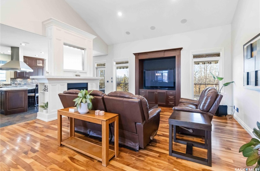 Living room featuring lofted ceiling, sink, and light hardwood / wood-style flooring