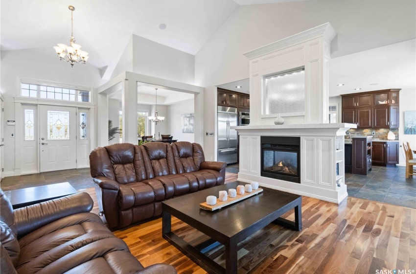 Living room with hardwood / wood-style flooring, a notable chandelier, and high vaulted ceiling