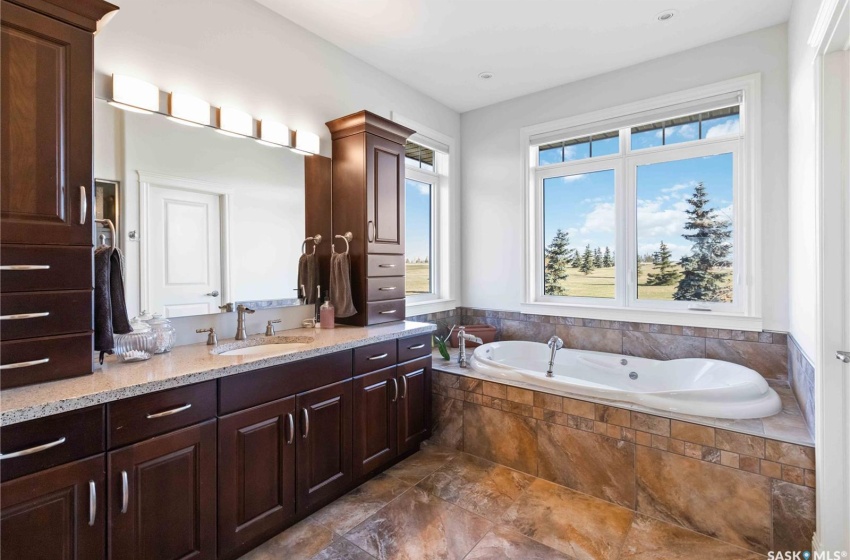 Bathroom featuring vanity and tiled bath