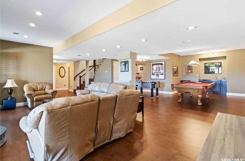 Living room with wood-type flooring and pool table