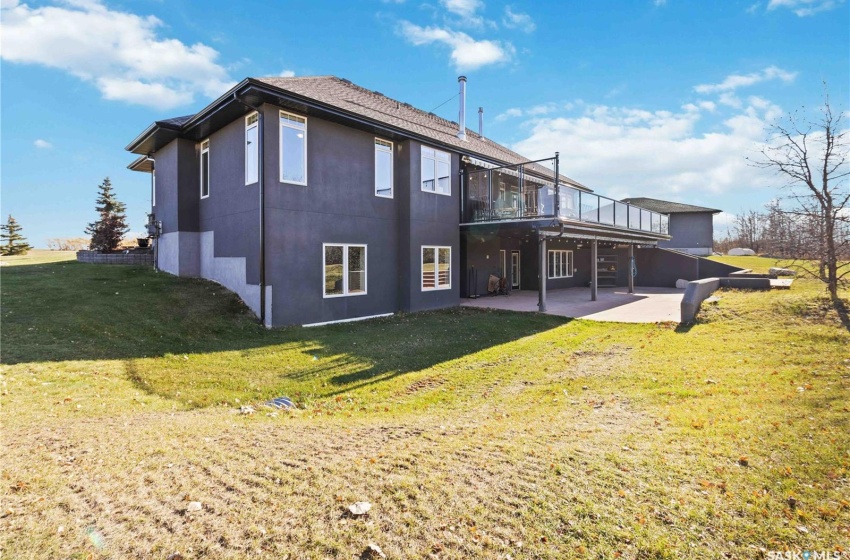 Back of property featuring a yard, a patio, and a wooden deck