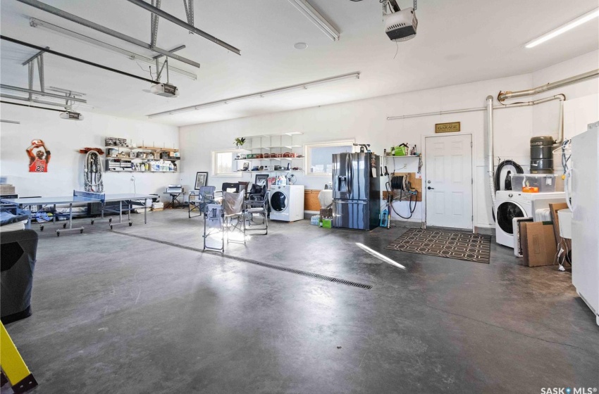 Garage with stainless steel fridge, washer / clothes dryer, and a garage door opener