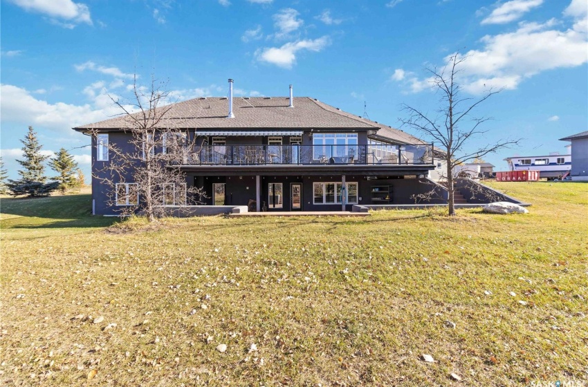 Back of property with a yard, a patio, and a wooden deck