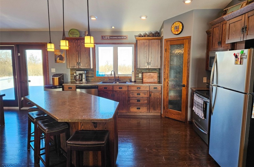 Kitchen with pendant lighting, appliances with stainless steel finishes, sink, and a wealth of natural light