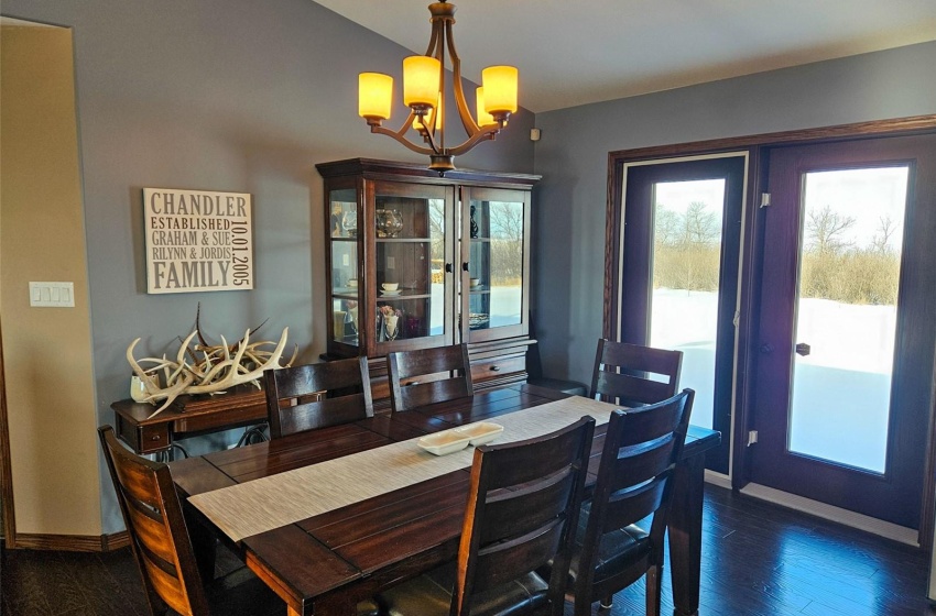 Dining space with an inviting chandelier, lofted ceiling, and dark hardwood / wood-style floors