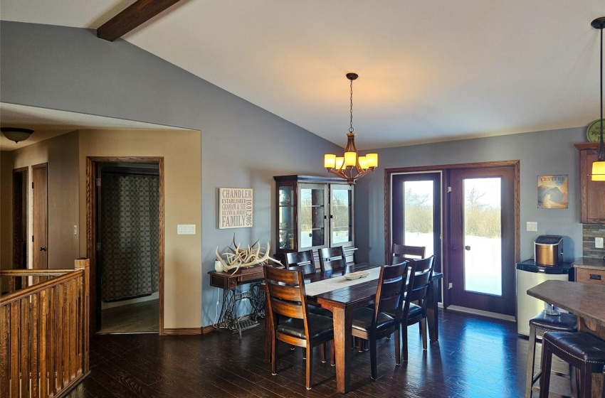 Dining room featuring an inviting chandelier, dark hardwood / wood-style flooring, and lofted ceiling with beams