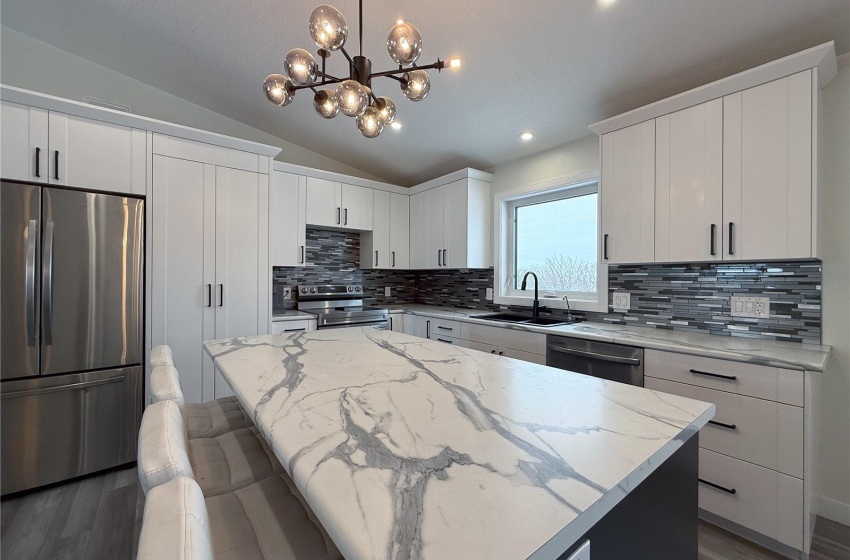 Kitchen with stainless steel appliances, a center island, sink, and white cabinets