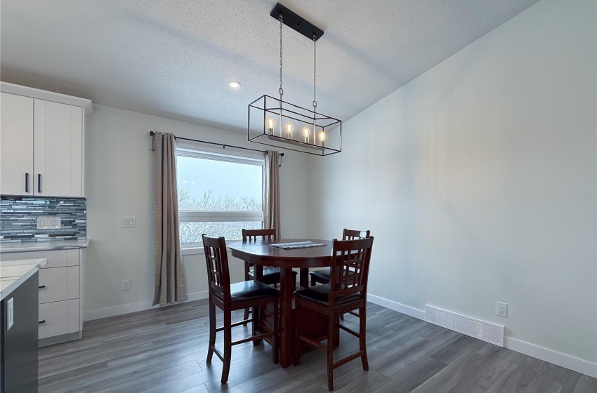 Dining area with dark hardwood / wood-style flooring and a textured ceiling