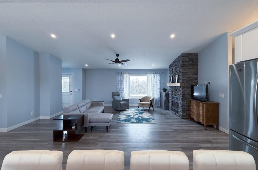 Living room featuring ceiling fan, a fireplace, and dark hardwood / wood-style flooring