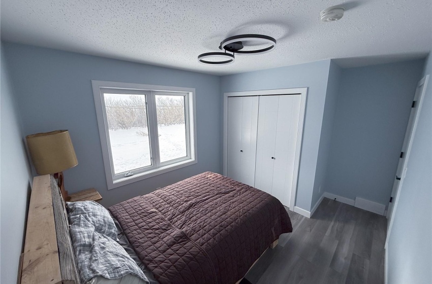 Bedroom featuring a closet, dark hardwood / wood-style floors, and a textured ceiling