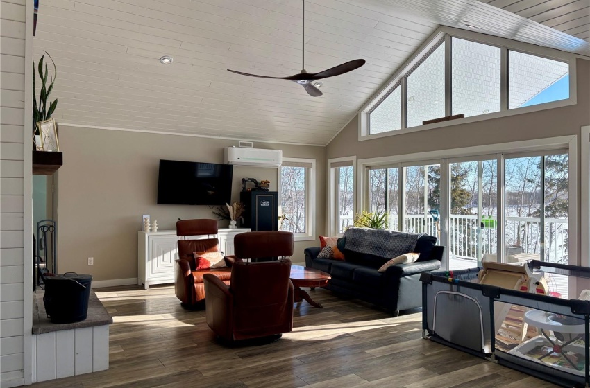 Living room featuring plenty of natural light, a wall mounted air conditioner, and dark hardwood / wood-style flooring