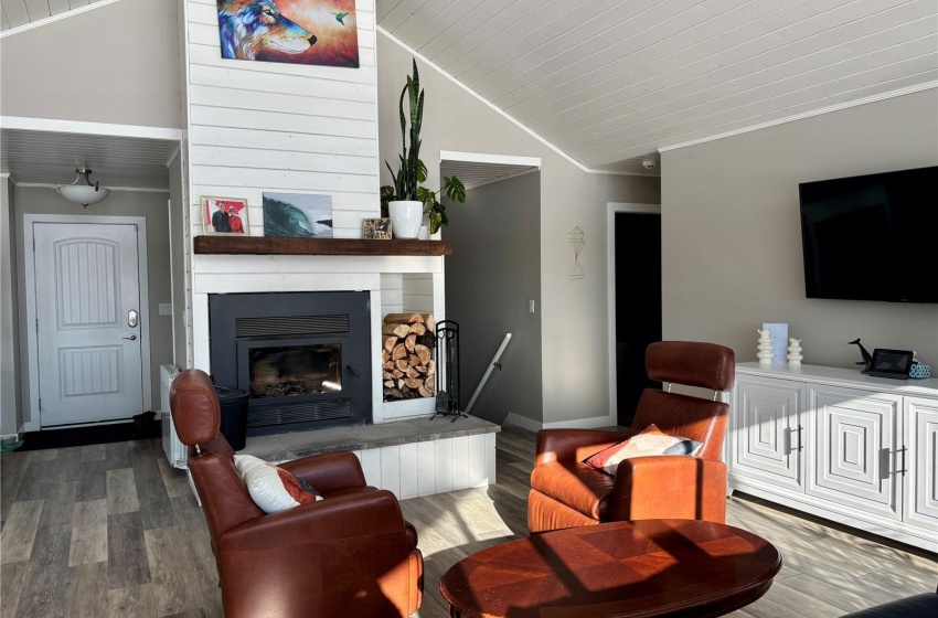 Living room with dark hardwood / wood-style floors, lofted ceiling, a large fireplace, ornamental molding, and wooden ceiling