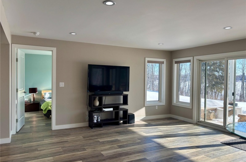 Basement family room with dark hardwood / wood-style floors and a healthy amount of sunlight