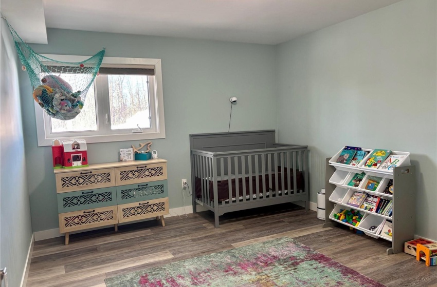 Bedroom featuring hardwood / wood-style flooring and a crib