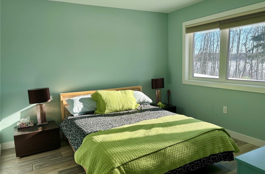 Bedroom featuring hardwood / wood-style floors and a lake view