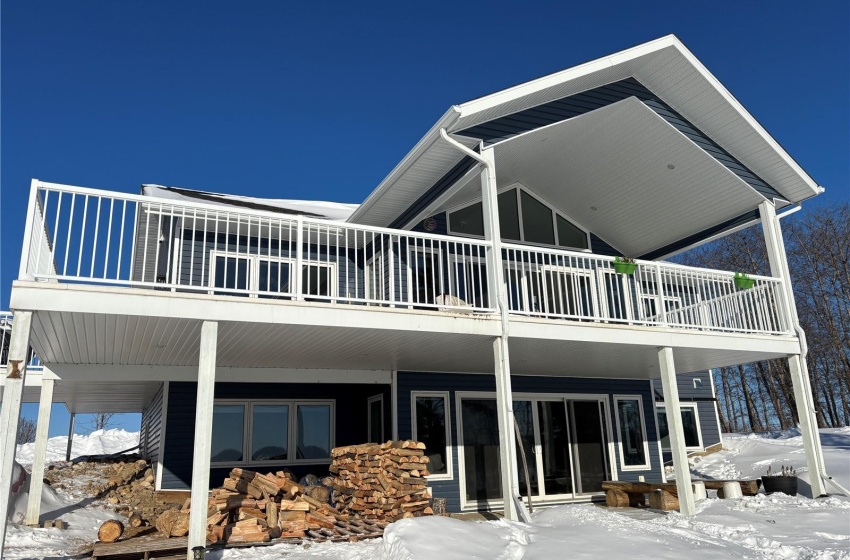 Snow covered rear of property featuring a balcony