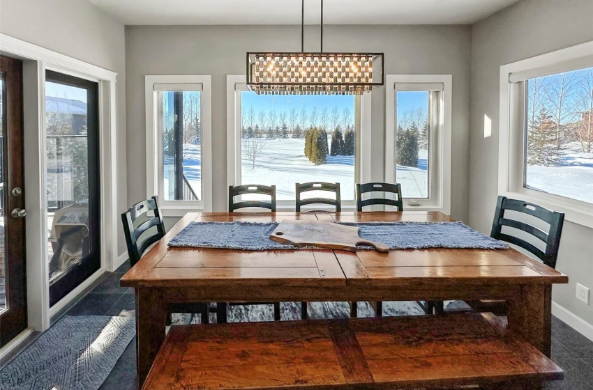 Large windows frame the dining area providing a view to the expansive lot framed by mature trees. Direct access to the BBQ and covered deck is easily accessible off this area.