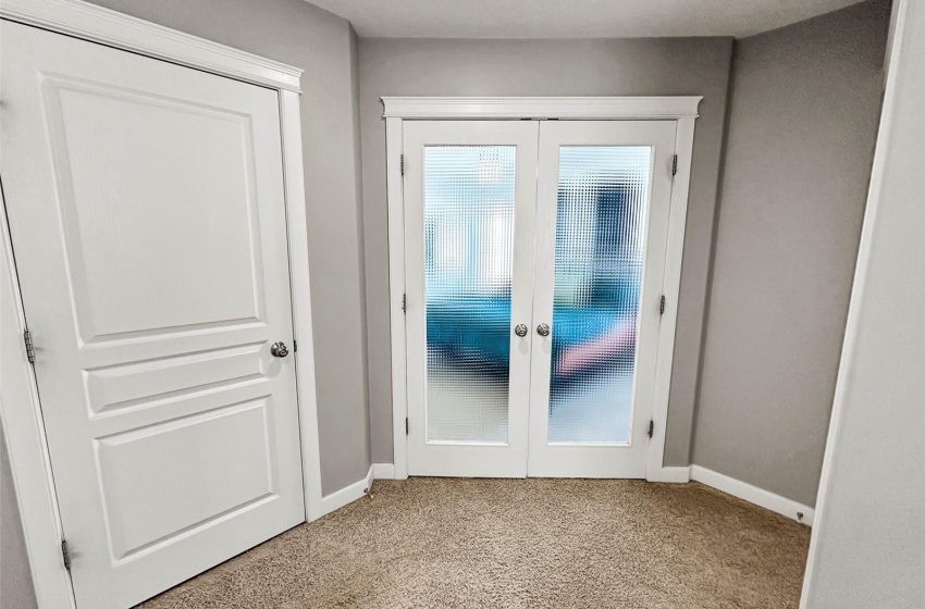 French doors lead to the Primary suite. A closet adjacent houses the washer/dryer.