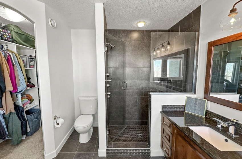 Double custom tiled shower, toilet and walk-in closet