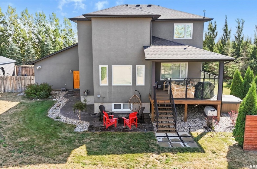 Covered deck and steps leading to a stamped concrete patio. Hot tub to the south.