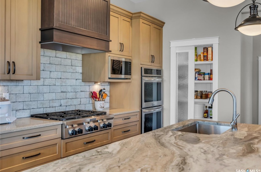 Stovetop and double wall ovens. Vent above stove directs outside.