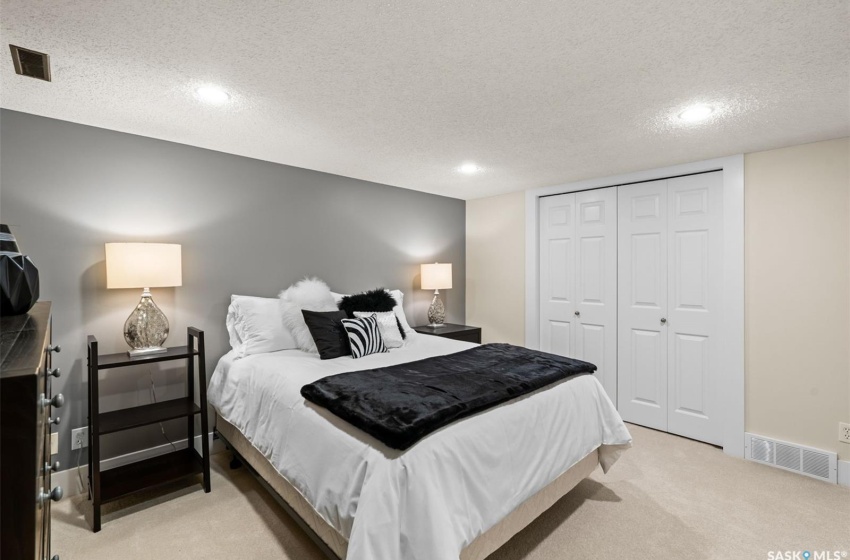 Carpeted den featuring a closet and a textured ceiling