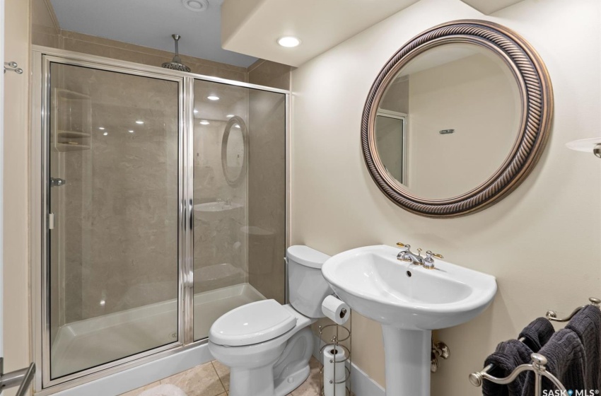 Bathroom featuring a shower with door, toilet, and tile patterned flooring