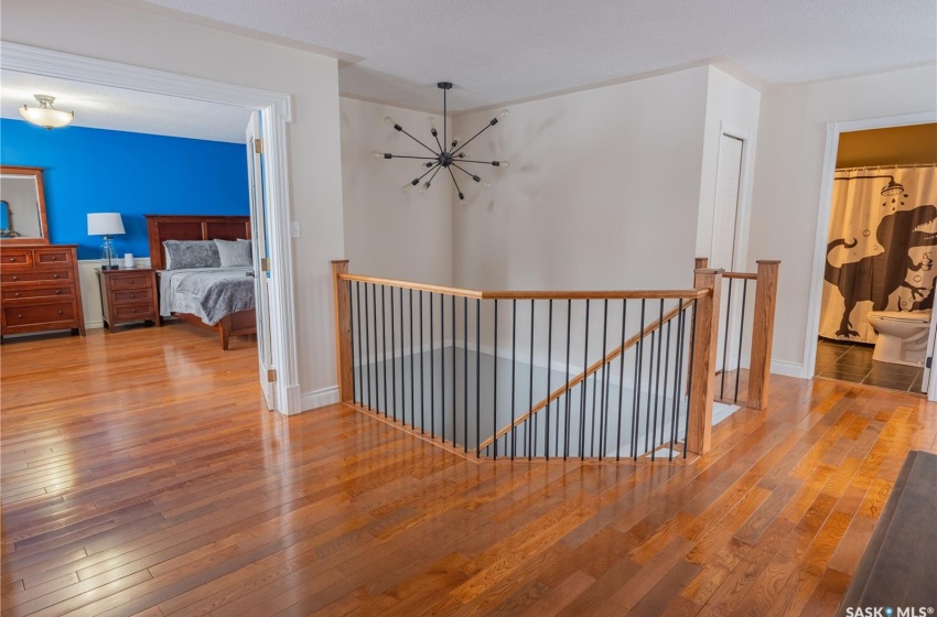 Corridor with baseboards, an upstairs landing, and wood finished floors