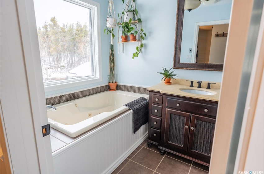 Bathroom featuring a jetted tub, vanity, and tile patterned floors