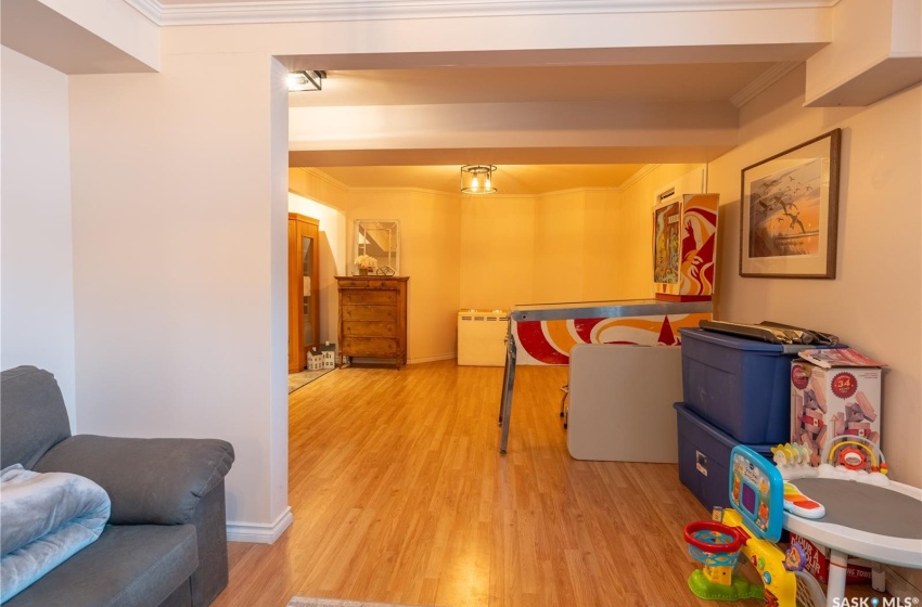 Recreation room with light wood finished floors, ornamental molding, and baseboards