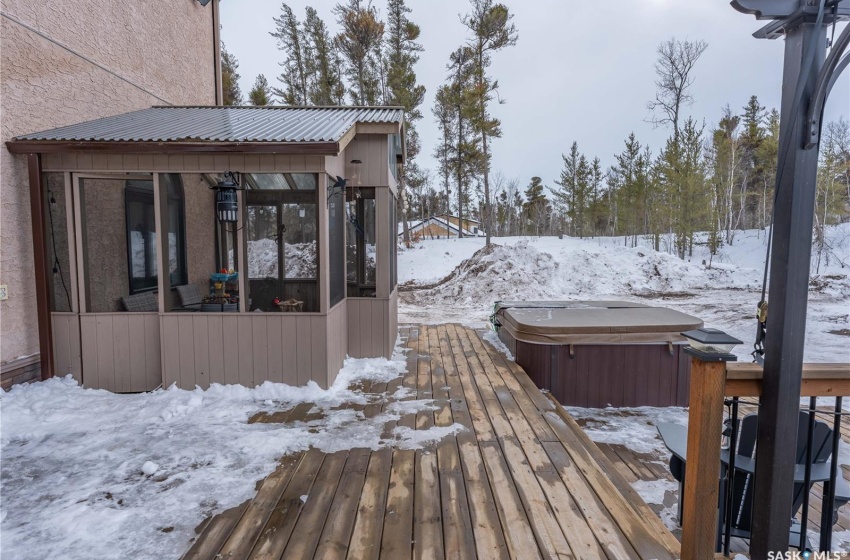 Snow covered deck featuring a hot tub