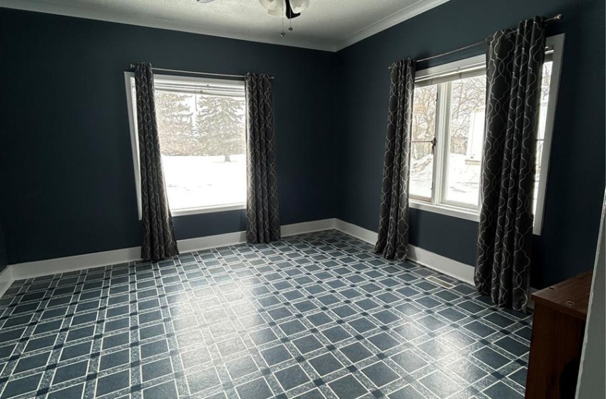 Spare room with baseboards, a ceiling fan, ornamental molding, tile patterned floors, and a textured ceiling