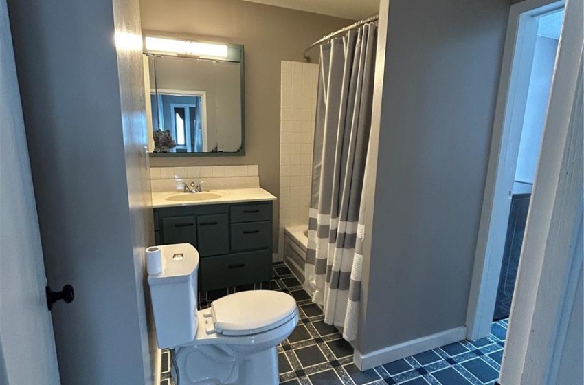 Full bath featuring a shower with shower curtain, baseboards, visible vents, and toilet