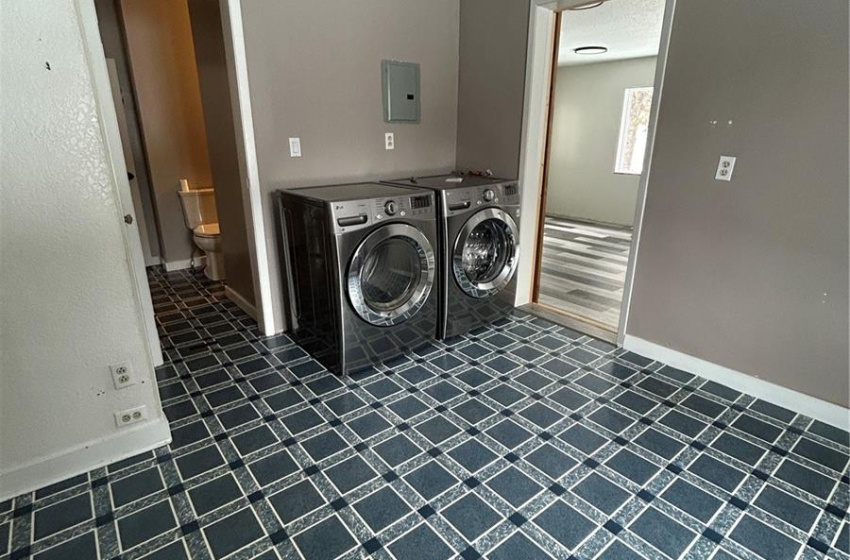 Clothes washing area featuring laundry area, baseboards, a textured ceiling, and washing machine and clothes dryer