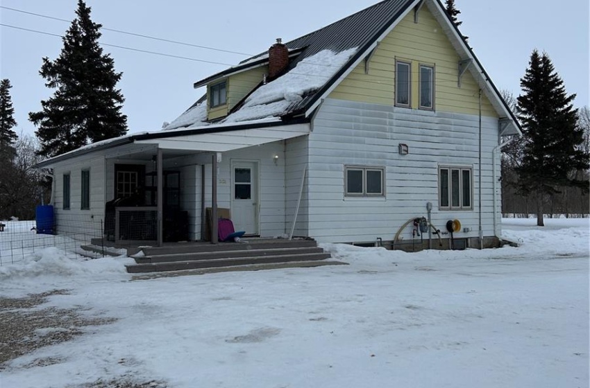 Snow covered rear of property with a chimney