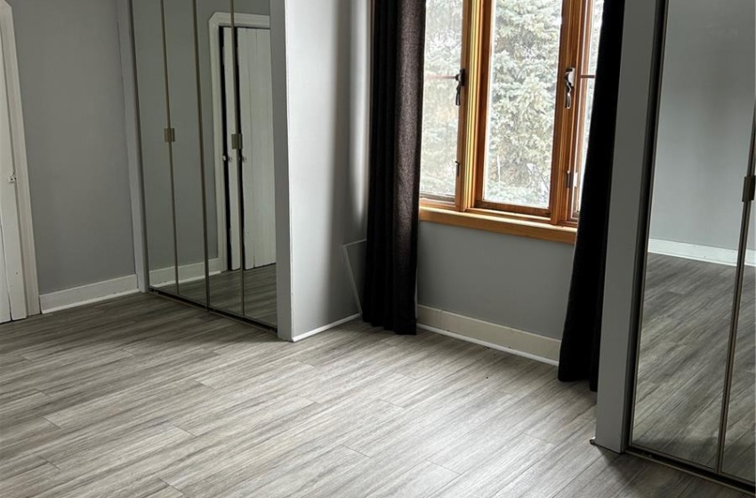 Unfurnished bedroom with a textured ceiling, baseboards, and wood finished floors