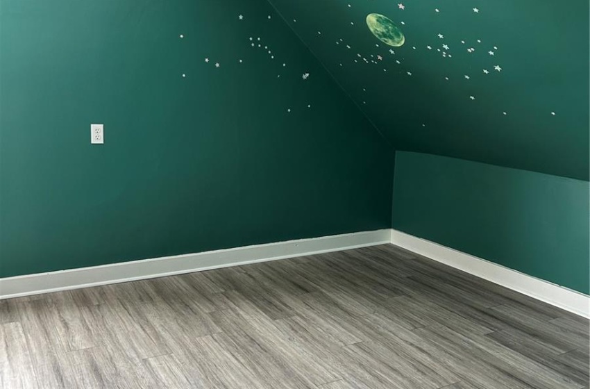 Bonus room featuring vaulted ceiling, a textured ceiling, wood finished floors, and baseboards