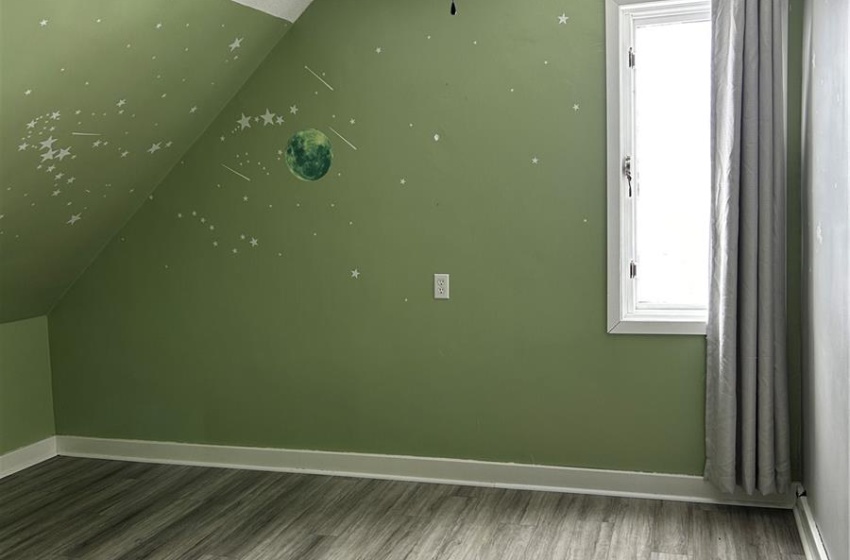 Additional living space with a textured ceiling, baseboards, vaulted ceiling, and wood finished floors