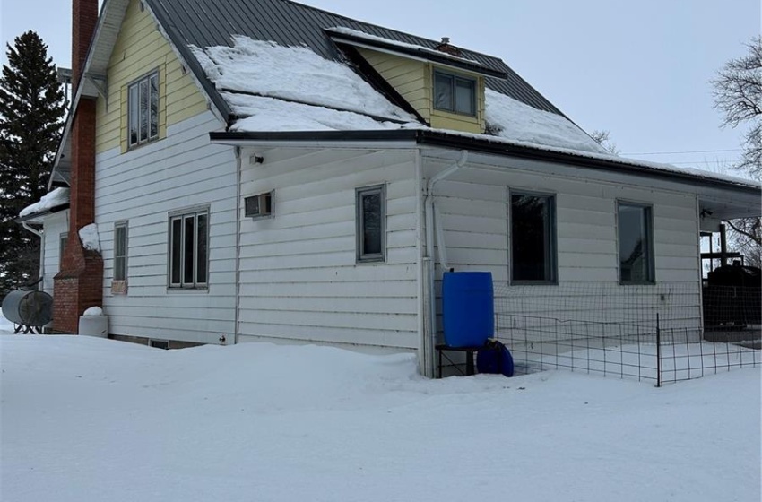 Snow covered rear of property featuring a chimney