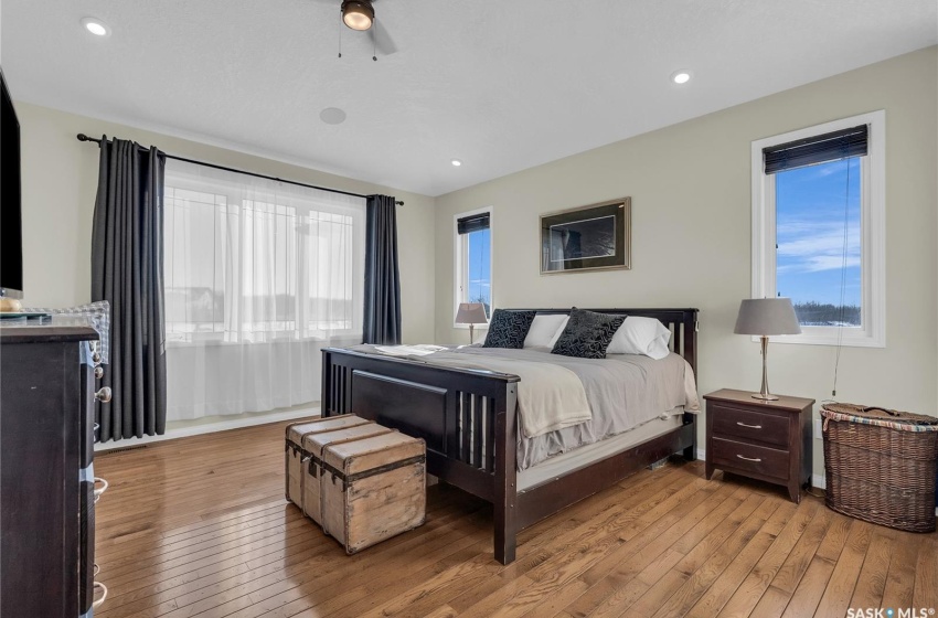 Bedroom with multiple windows and light wood-style flooring