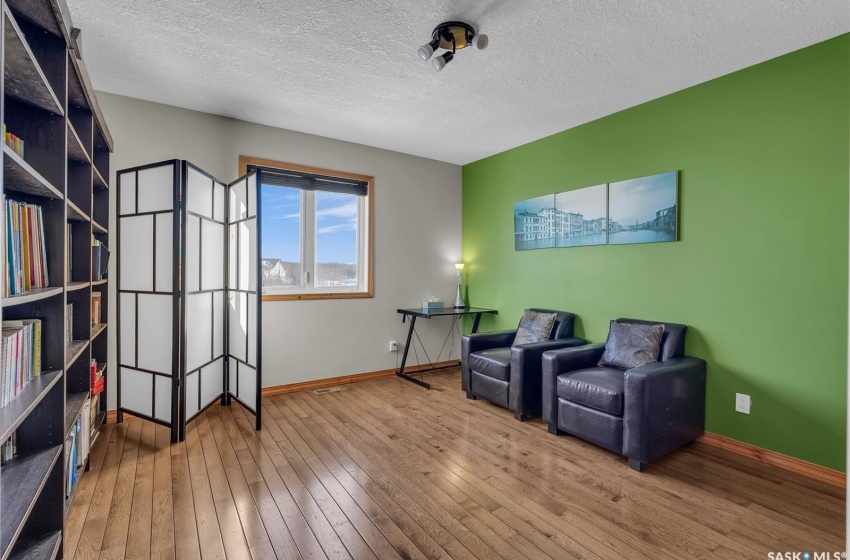 Sitting room featuring a textured ceiling, hardwood / wood-style floors, and baseboards