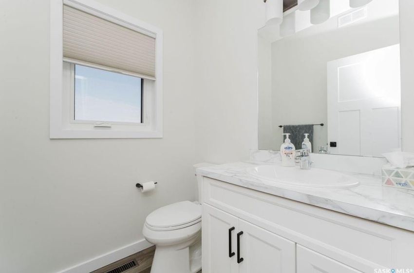 Bathroom featuring vanity, toilet, and hardwood / wood-style floors