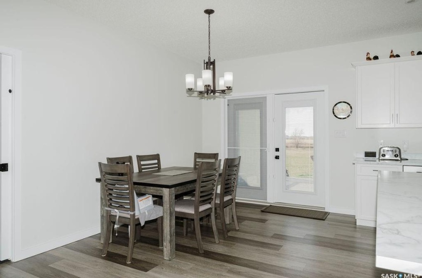 Dining area with a notable chandelier, a textured ceiling, and dark hardwood / wood-style flooring