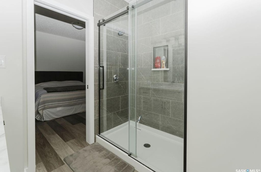 Bathroom with an enclosed shower, a textured ceiling, and hardwood / wood-style flooring