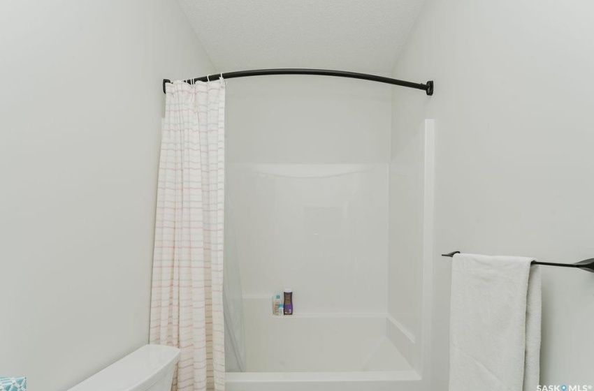 Bathroom featuring toilet and a shower with shower curtain