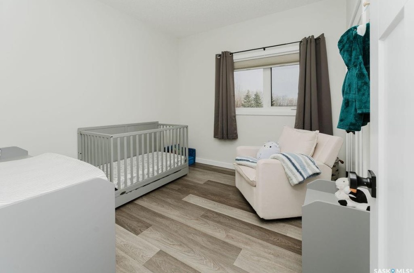 Bedroom with light hardwood / wood-style floors and a crib