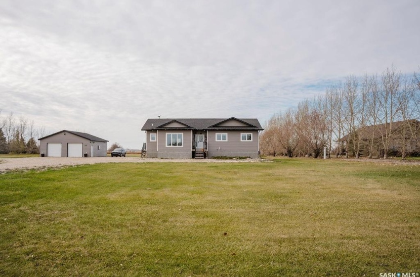 View of front of home featuring an outdoor structure, a front lawn, and a garage