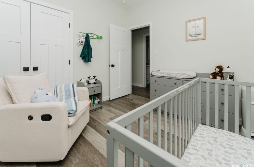 Bedroom featuring a crib and wood-type flooring