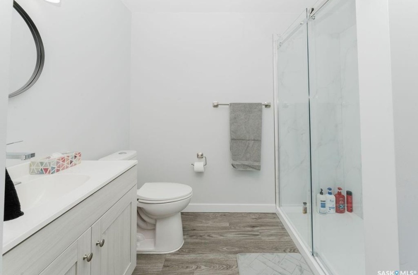 Bathroom featuring vanity, a shower with shower door, hardwood / wood-style flooring, and toilet