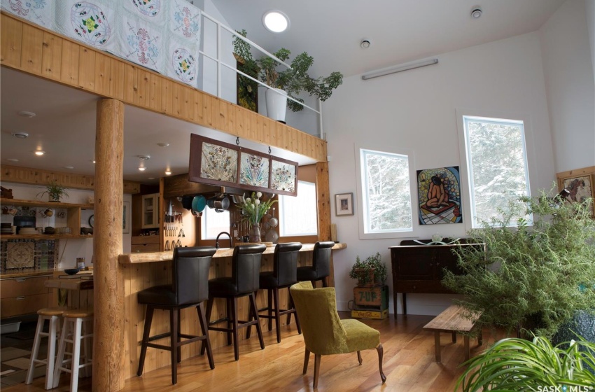 Bar featuring a towering ceiling and wood finished floors